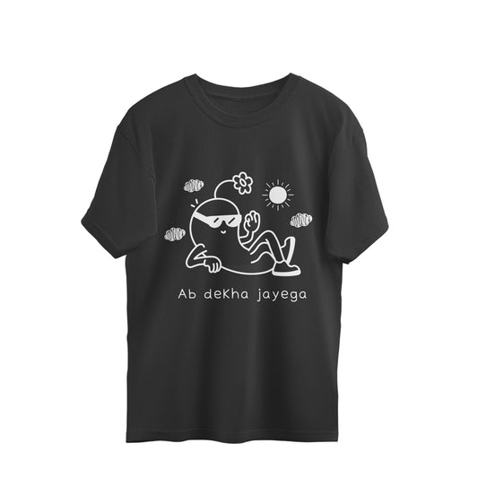Black front. Black oversized unisex tshirt printed with a white line drawing of a cartoon figure in sunglasses lounging on the ground under a sun and clouds, with the words Ab dekha jayega below